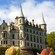 Tulips grow in front of a large castle